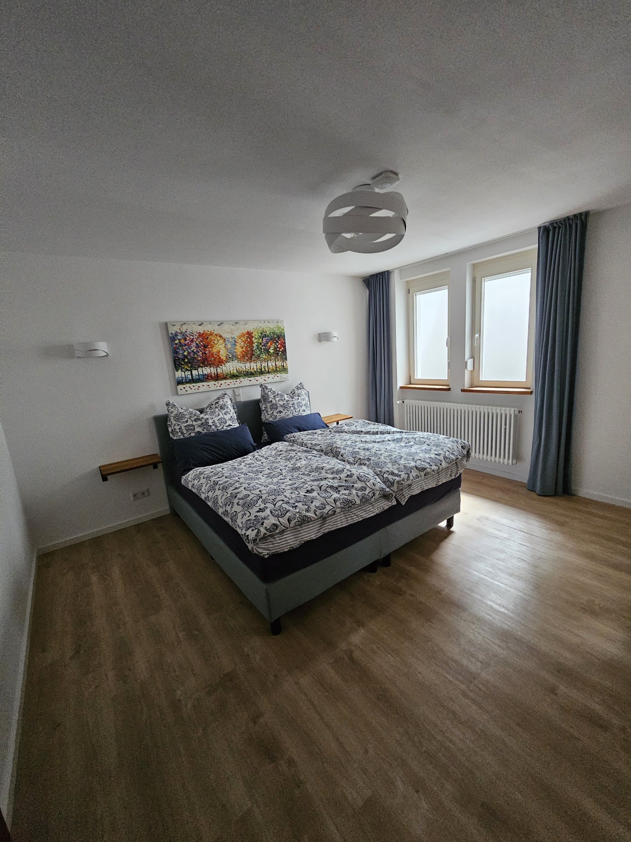 Schlafzimmer der Ferienwohnung mit Boxspringbett und großem Fenster