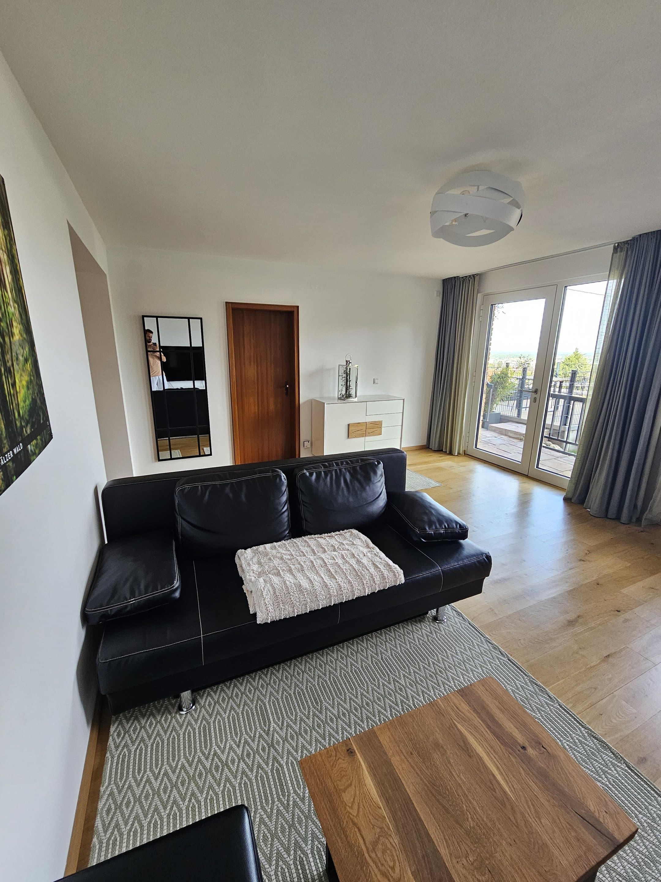 Wohnbereich der Ferienwohnung mit Sofa und Zugang zur Terrasse