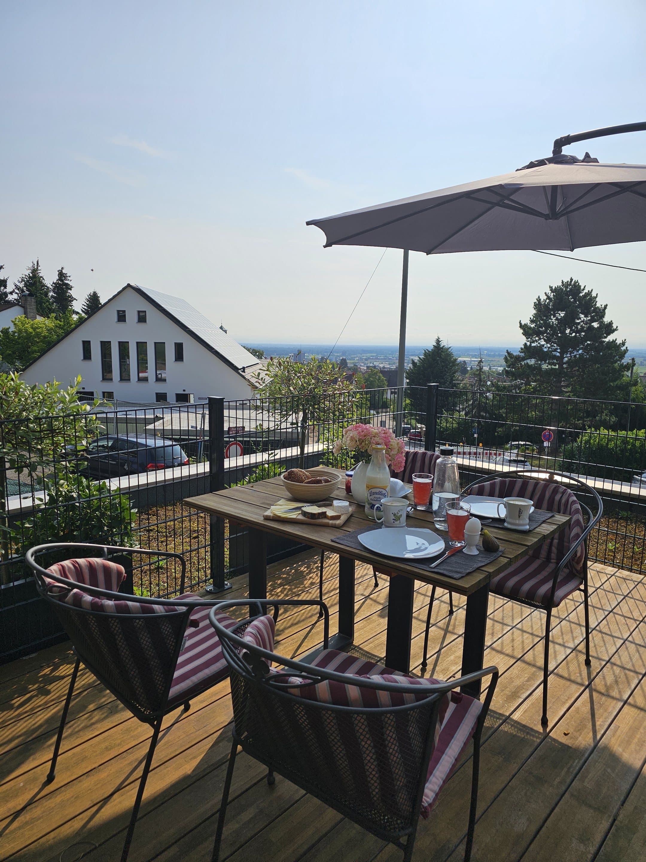 Gedeckter Terrassentisch der Ferienwohnung mit weitem Blick über die Rheinebene