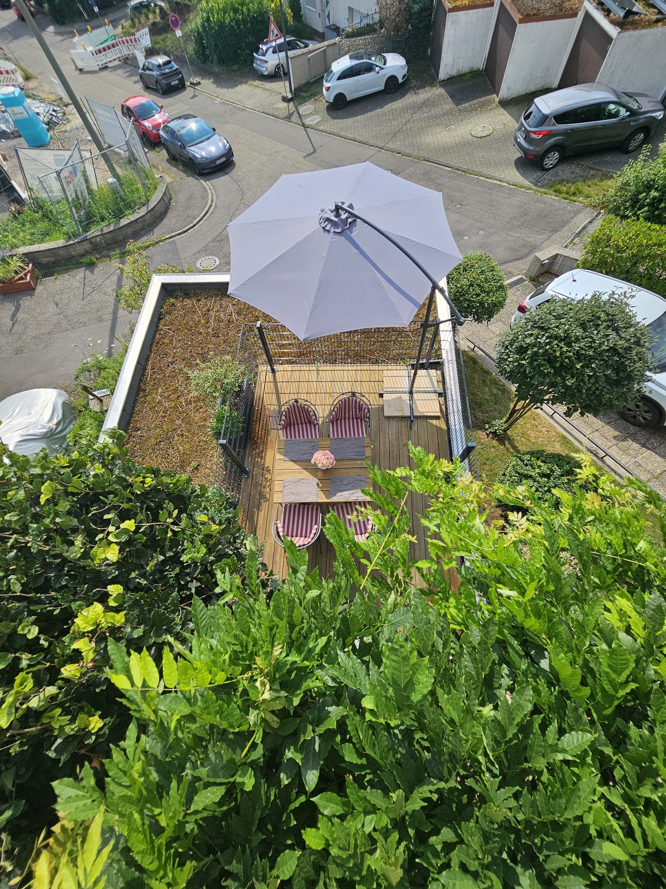 Terrasse der Ferienwohnung aus erhöhter Perspektive mit Sitzplatz und Sonnenschirm